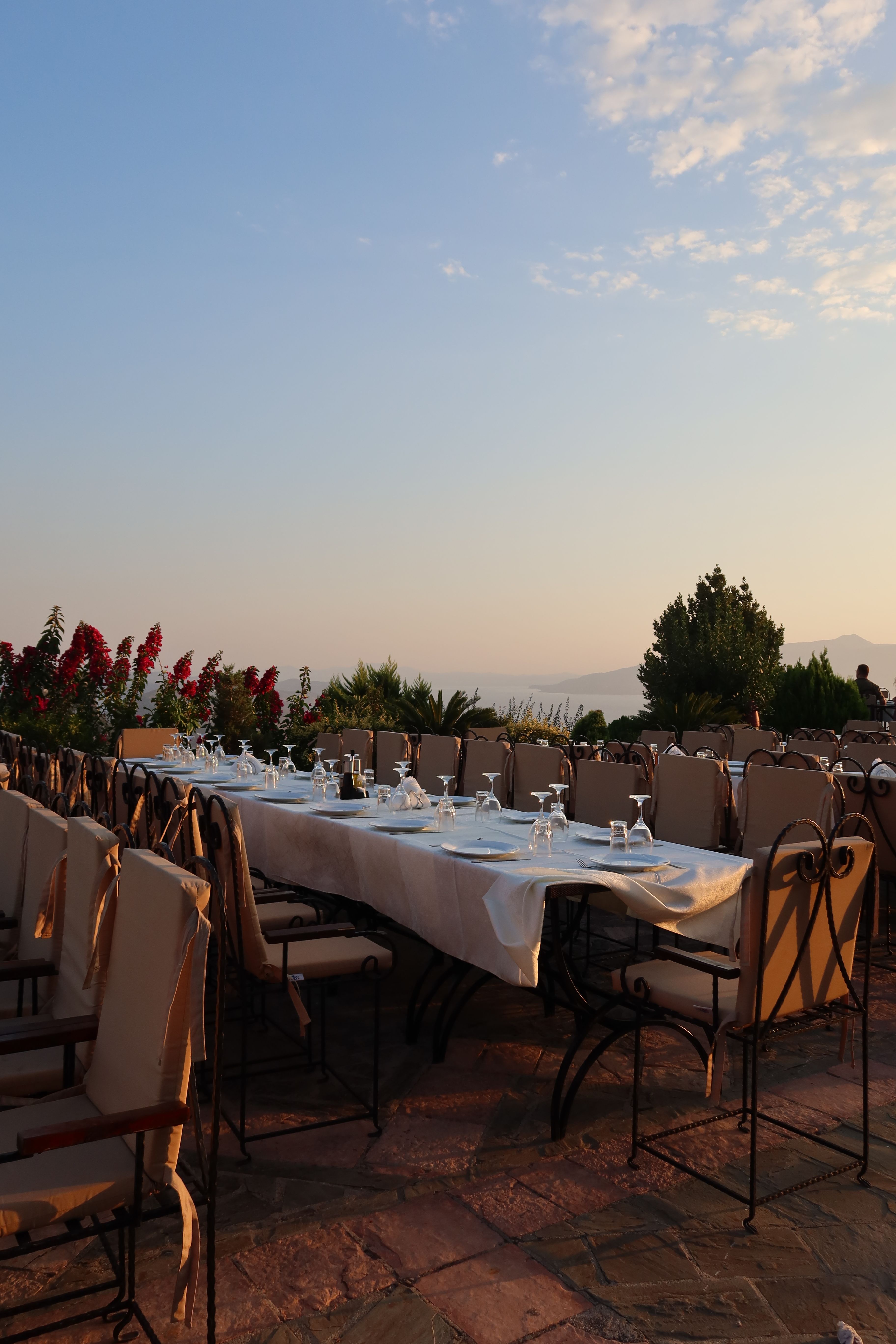 Long table prepared outdoors at sunset